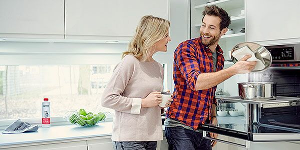 Un couple cuisine avec plaisir dans la cuisine. Même après avoir cuisiné, on peut rester détendu. Grâce aux produits de nettoyage proWIN, faire le ménage est un jeu d'enfant.